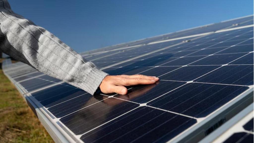 Mano sobre un panel solar